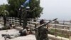 Lebanon -- Lebanese soldiers take up position as UN peacekeepers gesture towards Israeli soldiers at the Lebanese-Israeli border in Adaisseh village, 03Aug2010