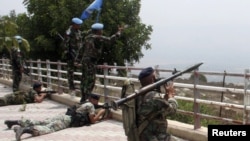 Lebanon -- Lebanese soldiers take up position as UN peacekeepers gesture towards Israeli soldiers at the Lebanese-Israeli border in Adaisseh village, 03Aug2010