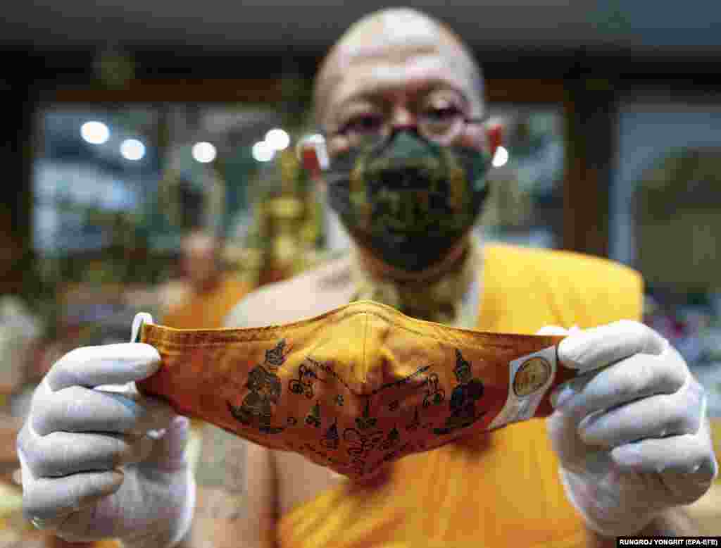 Thai Buddhist abbot monk Phra Kru Palad Sitthiwat holds a face mask he inscribed with spiritual incantations in Thailand&#39;s Nakhon Pathom Province on March 29.