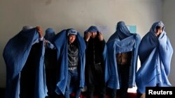 Male Afghan women's rights activists pose for media as they wear burqas to show their solidarity to Afghan women ahead of International Women's Day in Kabul on March 5.