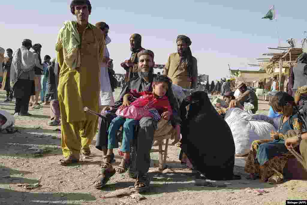 Afghan families stranded at the Afghan-Pakistan border on August 12. The Taliban has taken control of most of Kandahar Province and there has been heavy fighting in the provincial capital as government forces try to hold onto Kandahar city.