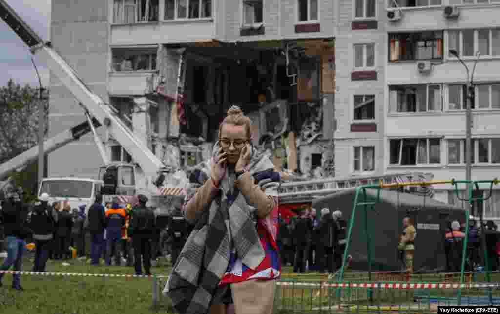 A woman passes rescue team members at work in the aftermath of a gas explosion at a nine-story residential building in Noginsk, outside Moscow, on September 8.