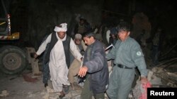 Afghan police and locals carry a wounded man from the site of a suicide attack in Trinkot city, southern Uruzgan province. (file photo) 