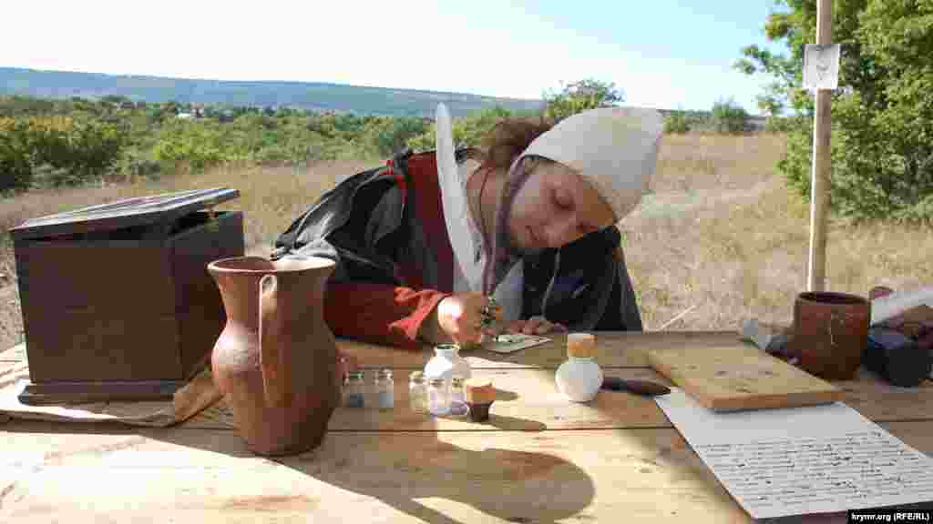Средневековый писарь показывает мастерство каллиграфии в лагере на Федюхиных высотах