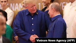 Президент США Дональд Трамп и президент России Владимир Путин (справа) во время обмена рукопожатиями. Дананг, 10 ноября 2017 года.