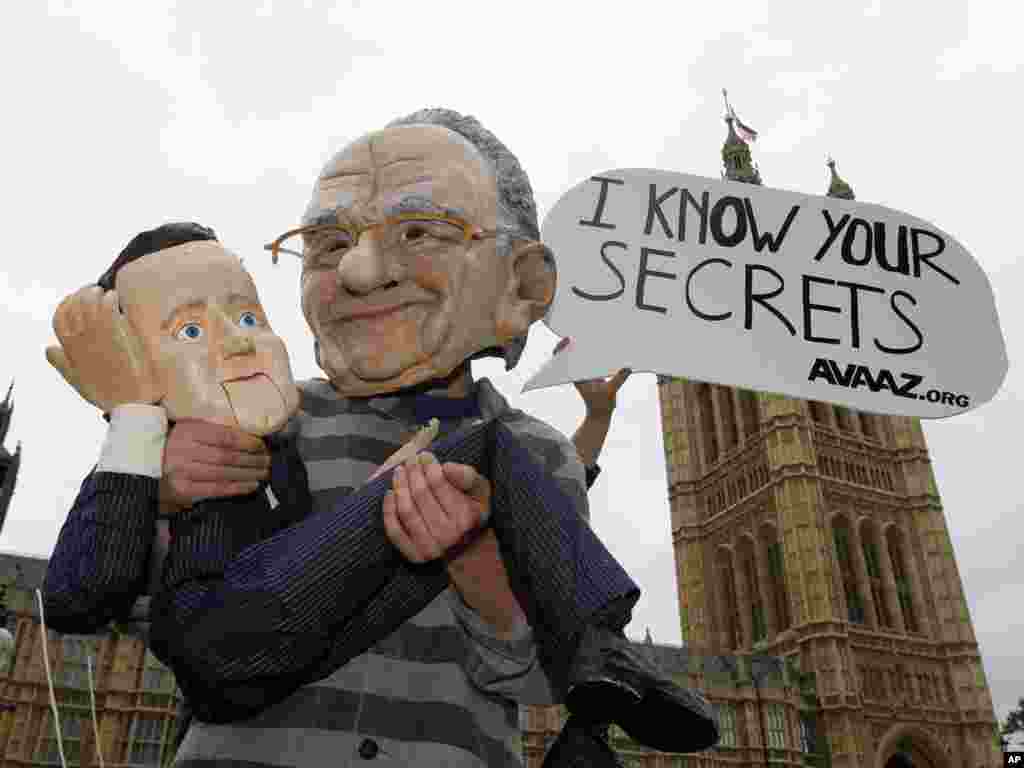 B&ouml;y&uuml;k Britaniya - Avaaz qrupunun fəalı Rupert Murdoch-un maskasını başına geyinib və qucağına da Baş nazir David Cameron-un kuklasını alaraq Londonda Parlamentin binası qarşısına &ccedil;ıxıb. Ş&uuml;arı da belədir: Mən sənin sirlərini bilirəm&q