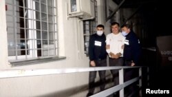 Бывшего президента Грузии Михаила Саакашвили, задержанного после возвращения в страну, сопровождают сотрудники полиции, когда он прибывает в тюрьму в Рустави, Грузия, 1 октября 2021 года. Кадр видеозаписи