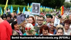 Чоловік із портретом головного командира УПА Романа Шухевича вирішив також пройтися разом із учасниками акції «Безсмертний полк». На нього не звертали уваги, допоки він не почав вигукувати гасло «Слава Україні!». Київ, 9 травня 2018 року 