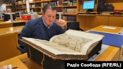 Журналіст Радіо Свобода Ростислав Хотин розглядає Генеральну карту України Гійома Левассера де Боплана в Саксонській державній бібліотеці в Дрездені