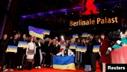 Guests of the Berlin Film Festival hold up signs in support of Ukraine on the anniversary of Russia's unprovoked invasion on February 24. 