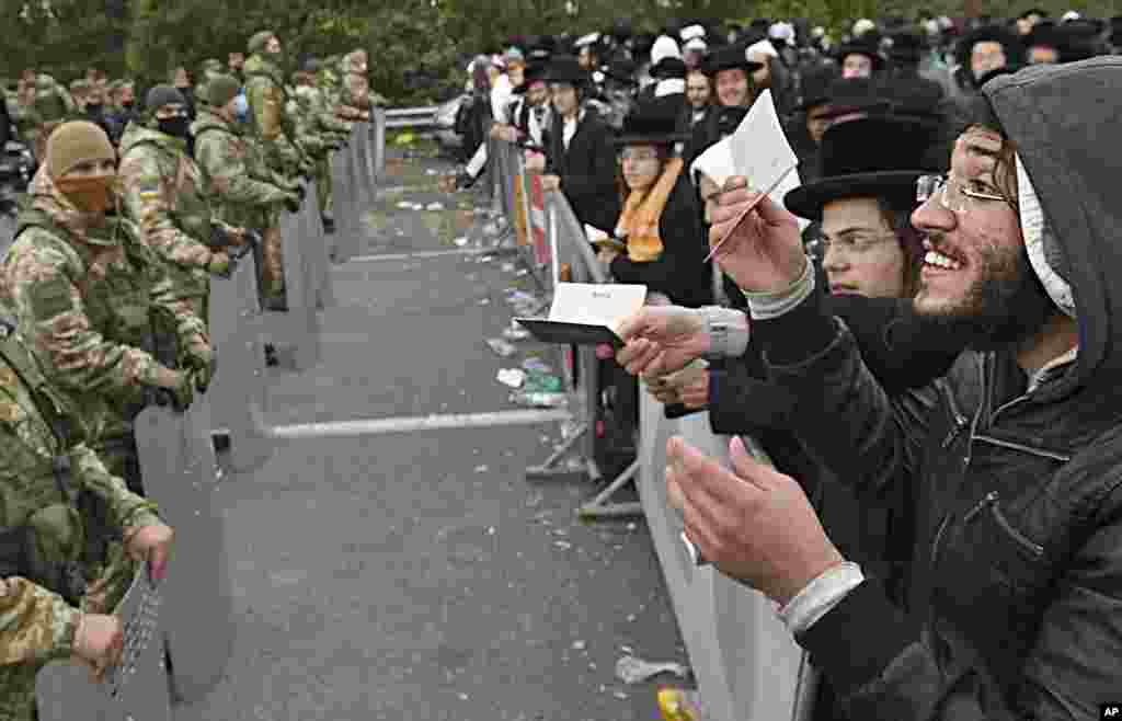 Hasidic Jewish pilgrims gather in front of Ukrainian border guards at the Novaya Guta checkpoint near Novaya Guta, Belarus, on September 18. Ukrainian officials said that thousands of Hasidic Jewish pilgrims stuck on the Ukrainian border due to coronavirus restrictions have started turning back. About 2,000 ultra Orthodox Jewish pilgrims traveled to Belarus&#39;s border with Ukraine in hope of traveling to the Ukrainian city of Uman to visit the grave of an important Hasidic rabbi who died in 1810. (AP)