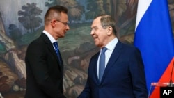 Maghiarul Peter Szijjarto (stânga) dând mâna cu Serghei Lavrov la Moscova în iulie 2022. 