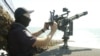 An officer operates a machine gun used to take down Russian drones. 