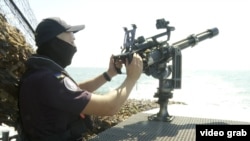 An officer operates a machine gun used to take down Russian drones. 