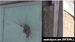 Пашкоджаныя дзьверы вясковага дому на армянскім баку мяжы.