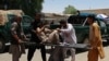 Afghan men carry a victim of a powerful car bomb in Lashkar Gah on June 22.