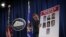 WASHINGTON, DC - MARCH 24: A Department of Justice employee put up a poster of the seven indicted hackers prior to a news conference for announcing a law enforcement action March 2