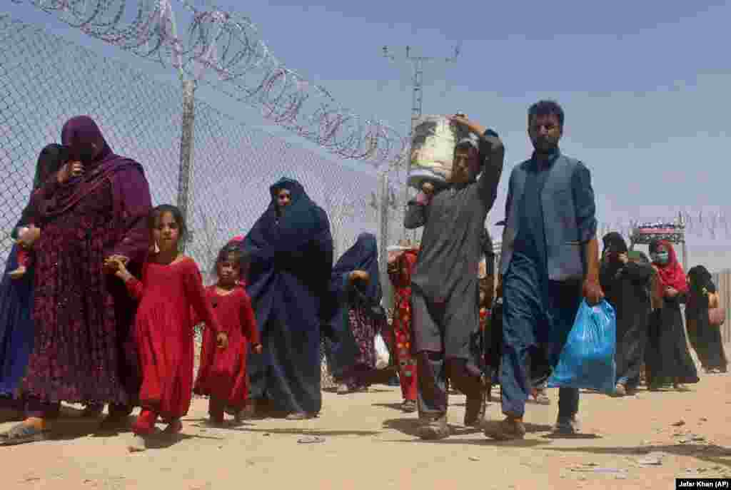 Afghans walk through a security barrier as they enter Pakistan at Chaman on August 27.