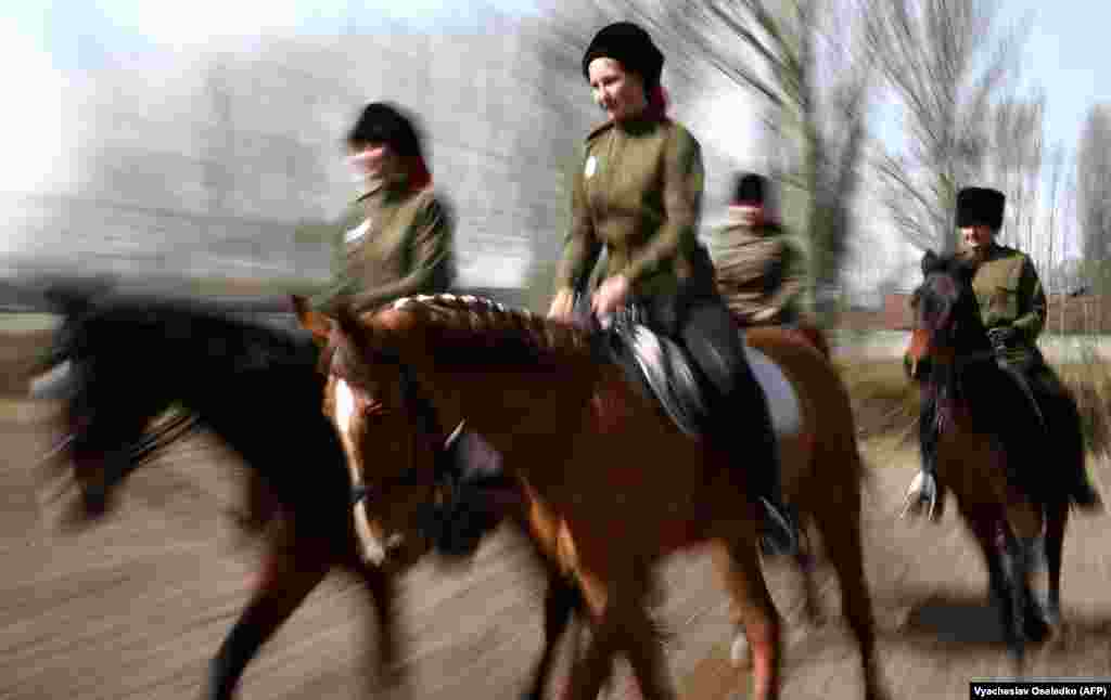 Women riders wearing Cossack uniforms take part in a parade before an equestrian sports tournament in Bishkek, Kyrgyzstan. (AFP/Vyacheslav Oseledko)