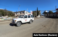 International Committee of the Red Cross members drive through the town of Hadrut.