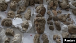 Pieces of statues damaged by the Taliban are laid out on a table for restoration at the National Museum in Kabul in October 2019.