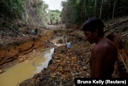 Pripadnik naroda Janomami prati agente brazilske agencije za okoliš u rudniku zlata tokom operacije protiv ilegalnog iskopavanja zlata na autohtonoj zemlji, u srcu amazonske prašume, u državi Roraima, Brazil 17. april 2016.