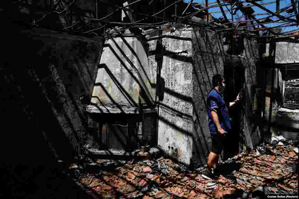 Giorgos Christodoulou duke qëndruar brenda shtëpisë së tij të djegur, pas një zjarri të egër pranë fshatit Drosopigi, në veri të Athinës, në Greqi. (8 gusht)