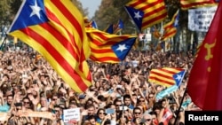 People react as they watch on giant screens a plenary session outside the Catalan regional parliament in Barcelona, Spain, October 27, 2017