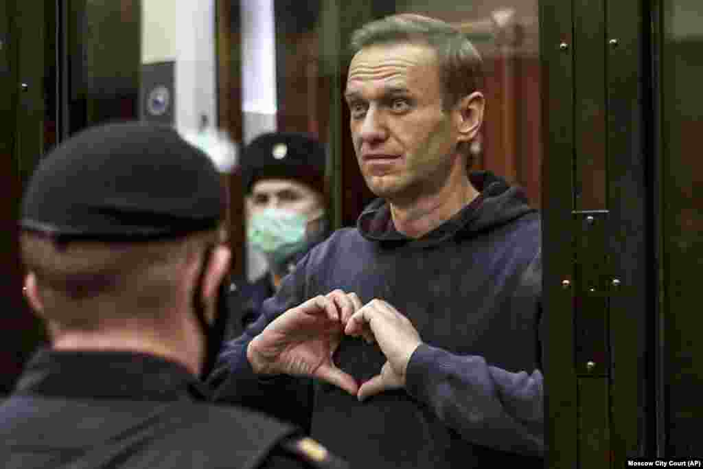 Navalny makes a heart symbol for his wife, Yulia, while standing in a cell during his Moscow court hearing on February 2.