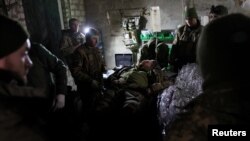Medicii și membrii Brigăzii 24 din Ucraina tratează un soldat rănit lângă Bakhmut, în regiunea Donețk, pe 1 decembrie.