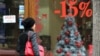 Armenia - A woman walks past a Yerevan shop announcing a Christmas price discount, 20Dec2011.