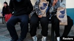 مهاجران اخراجی از ایالات متحده به گواتمالا، بیرون از مرکز بازگشت دیده می‌شوند. 