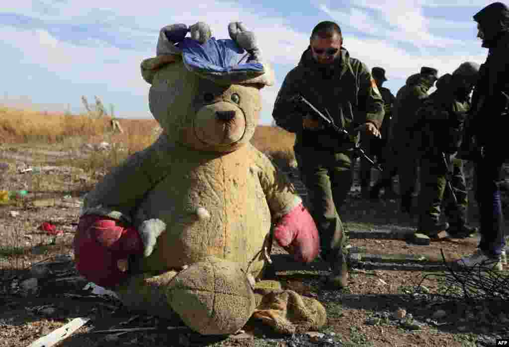 Pro-Russian rebel sappers walk past a giant teddy bear as they search for explosive devices in the destroyed Donetsk International Airport. Ukrainian forces lost control of the airport in January 2015. (AFP/Aleksei Filippov)