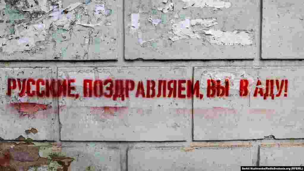 Такі графіті з написом російською мовою &laquo;Русские, поздравляем, вы в аду!&raquo; з&rsquo;явилися на вулицях одного з населених пунктів на Донеччині, що неподалік від лінії фронту. Його контролюють військові ЗСУ, 29 апреля 2022 года