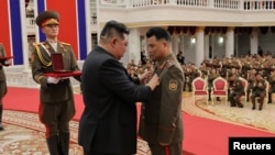Dictatorul Kim Jong Un decorează un comandant al Armatei Populare Coreene, la sediul Comitetului Central al Partidului Muncitorilor Coreeni din Phenian, Coreea de Nord. Fotografie publicată pe 22 august 2025 de Agenția Centrală de Știri Coreeană (KCNA).