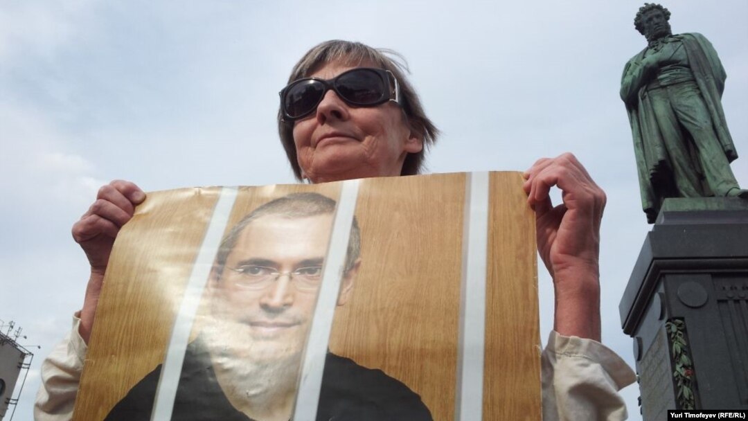 A woman in Moscow holds a portrait of Mikhail Khodorkovsky to mark his continued imprisonment on his birthday in June 2012.