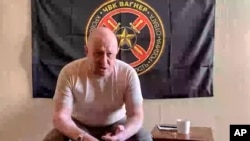 Prigozsin a sajtószolgálata által 2023. június 23-án, pénteken közzétett, videóról készült felvételen. Mögötte a Wagner zászlaja