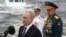 Russian President Vladimir Putin (left) and Defense Minister Sergei Shoigu attend Navy Day celebrations in St. Petersburg on July 31. 