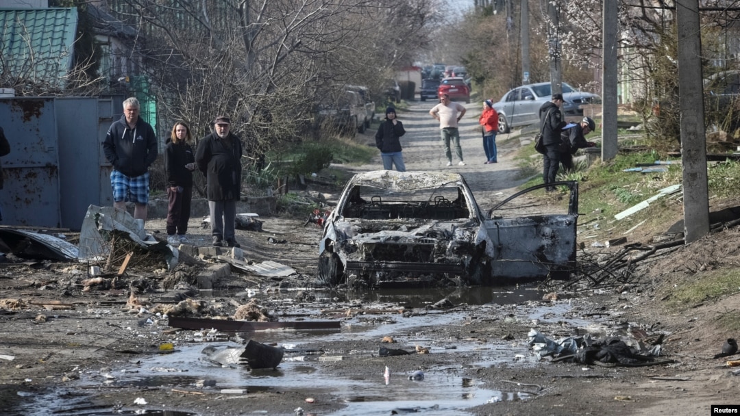 Dnipro residents inspect the aftermath of a Russian drone strike on the Ukrainian city late on March 28.