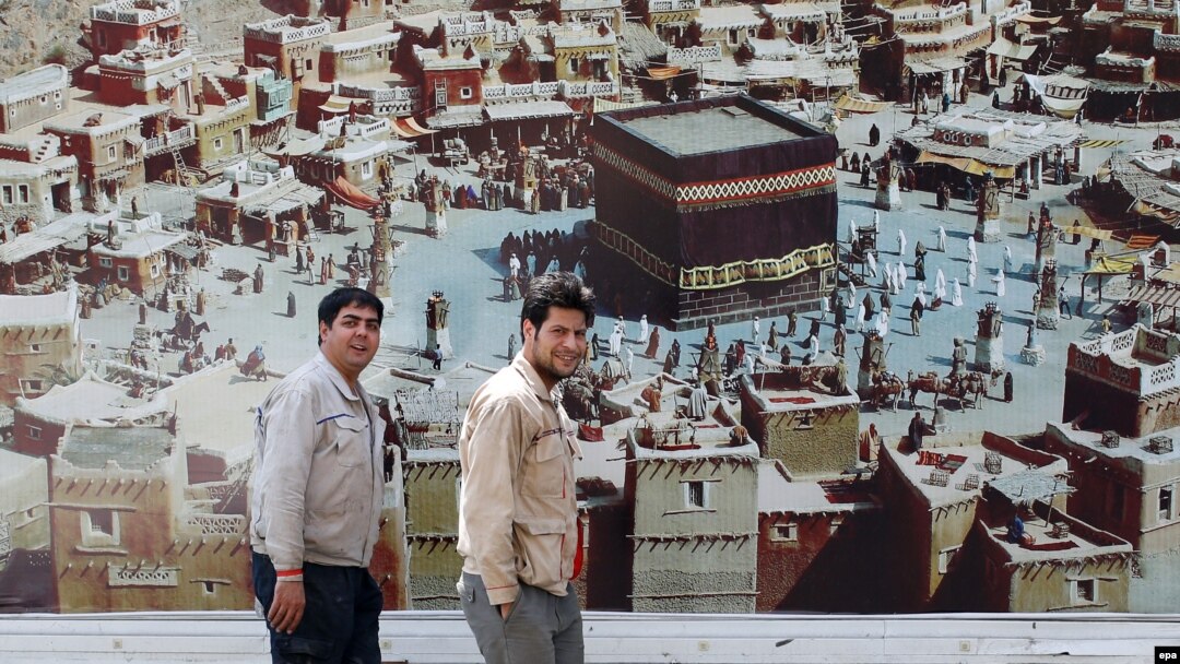 Иранда илинип турган "Мухаммед" тасмасынын жарнагынын жанында өтүп бараткан адамдар. Тегеран, Иран, 14-сентябрь, 2015-жыл