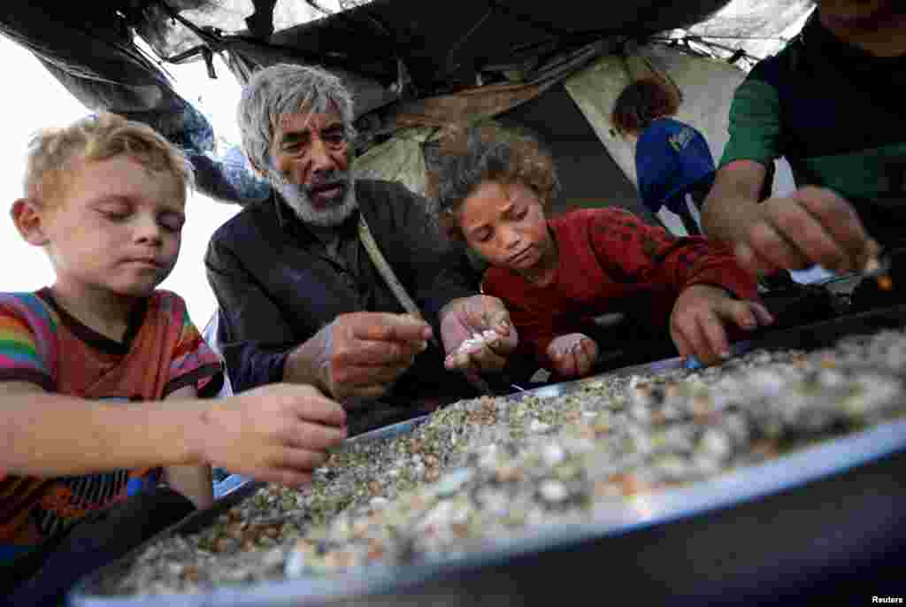 Raseljeni Palestinci koji nisu primili humanitarnu pomoć okupljaju se dok preživljavaju od ostataka hrane, usred krize gladi, u Gazi, 28. jula 2025.