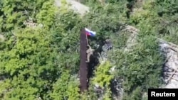 Ուկրաինա - Ռուս զինվորը Ռուսաստանի դրոշն է բարձրացնում Դոնեցկի մարզի Յաբլունիվկա բնակավայրում, 12-ը օգոստոսի, 2025թ.