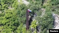 Un stop-cadru dintr-un videoclip difuzat de Ministerul Apărării rus arată un soldat rus care ridică steagul la Iablunivka, în regiunea Donețk. Rușii anunță des că au mai cucerit sate în zona respectivă. 