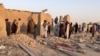 Residents stand amid the rubble of a house damaged in a Pakistani air strike on the Garmsir district of Afghanistan's Helmand Province on October 1.  