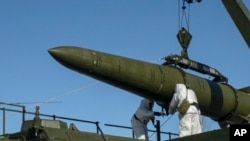 Russian troops load an Iskander missile onto a mobile launcher during drills at an undisclosed location in Russia. (file photo)