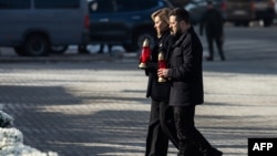 Ukrainian President Volodymyr Zelenskyy (right) and first lady Olena Zelenska hold candles during a ceremony to mark the third anniversary of Russia's all-out invasion of Ukraine, on Independence Square in Kyiv on February 24.