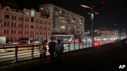 Cars pass as street lights are off in Kyiv on November 1 amid rolling blackouts across Ukraine.