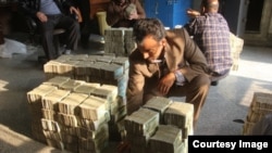 Piles of banknotes being smuggled are inspected by customs officials.