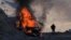 NAGORNO-KARABAKH - A man stands near his burning car which caught on fire during the climb along the road to a mountain pass, near the border between Nagorno-Karabakh and Armenia, Sunday, Nov. 8, 2020