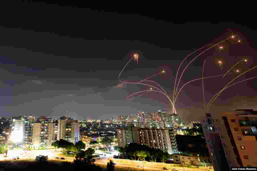 Световые полосы в небе во время применения израильской противоракетной системы Iron Dome, которая перехватывает ракеты, запущенные из сектора Газа в направлении Израиля. Вид с Ашкелона, Израиль, 10 мая 2021 года&nbsp;
